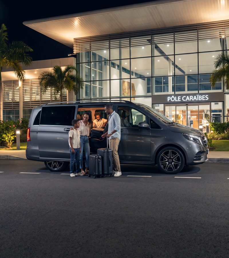 Famille chargeant ses valises devant le terminal Pôle Caraïbes, de nuit